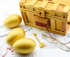 Three golden eggs and a golden key with a wooden chest on business and financial reports : Key success in sustainable growth investment concept
